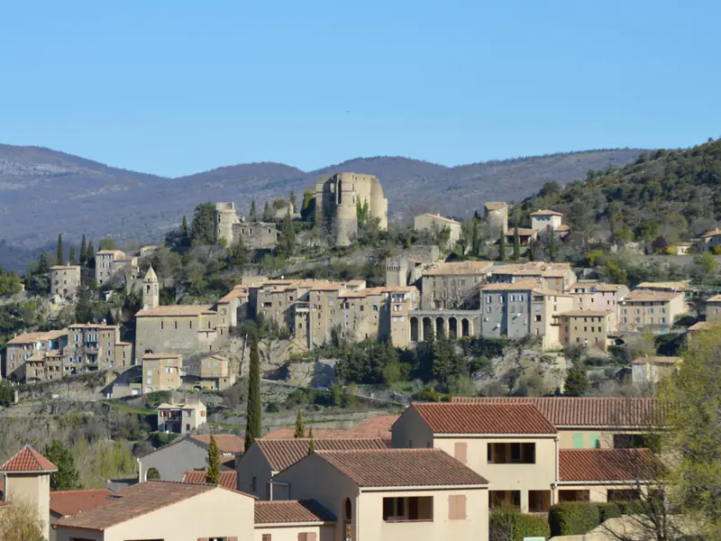 Montbrun-les-Bains auf seinem Hügel, mit Burgruine, Kirchturm und Arkaden